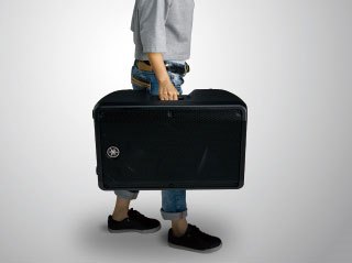 Person carrying a DBR speaker by the handle.