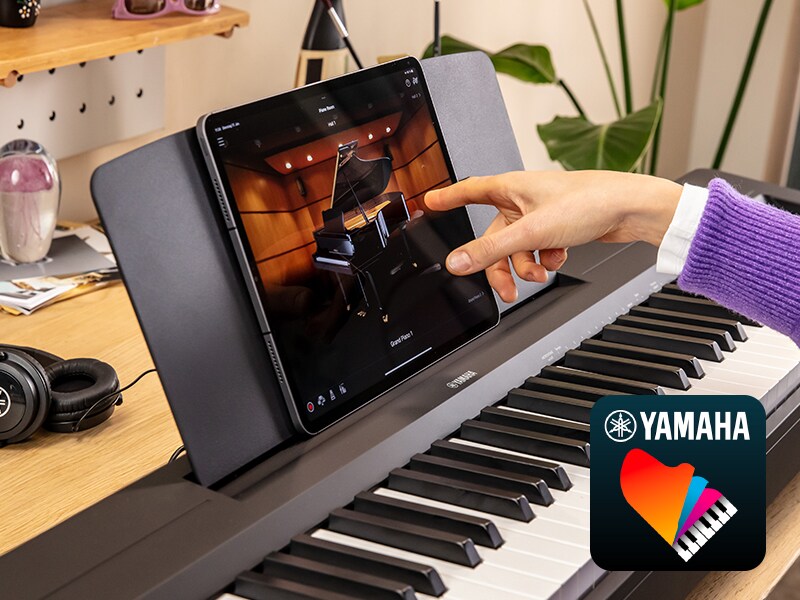 The Yamaha “Smart Pianist” app icon, together with a tablet placed on the music stand of the …