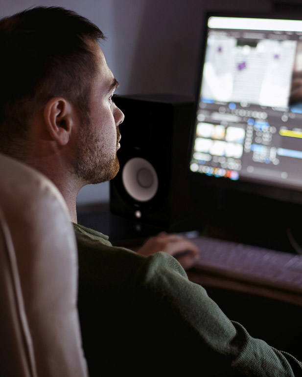 Person editing music while using Yamaha studio monitors.