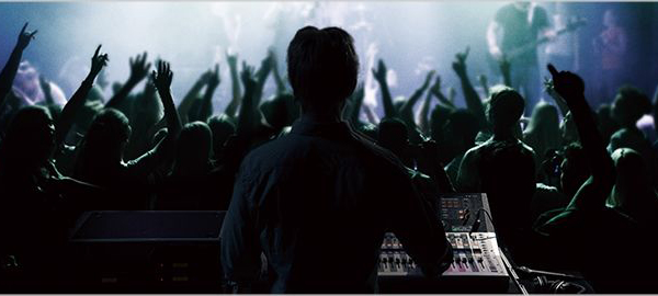 Person controlling a TF series mixer at a live concert.