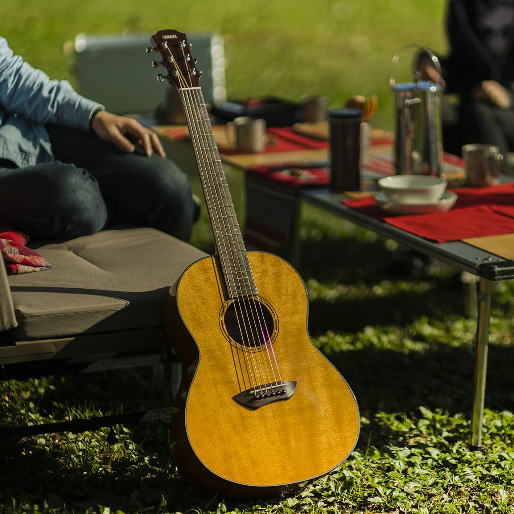 Guitar propped against a chair in an outdoor setting.