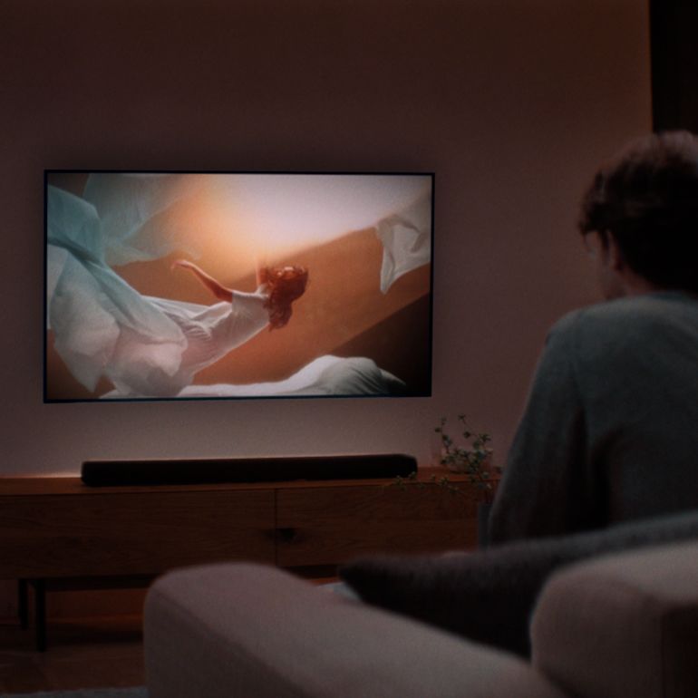 Image of a man watching TV with Yamaha TRUE X BAR 50A