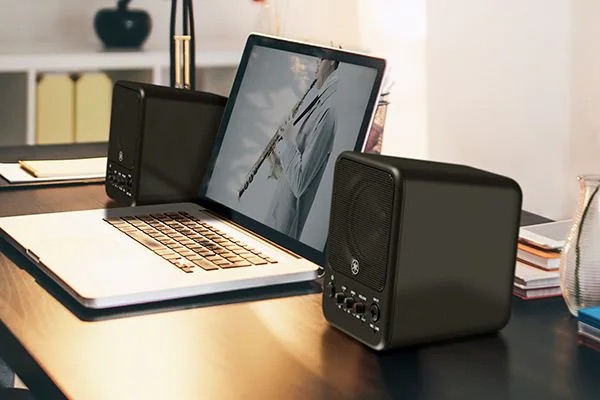 Two MS101-4 speakers next to a laptop.