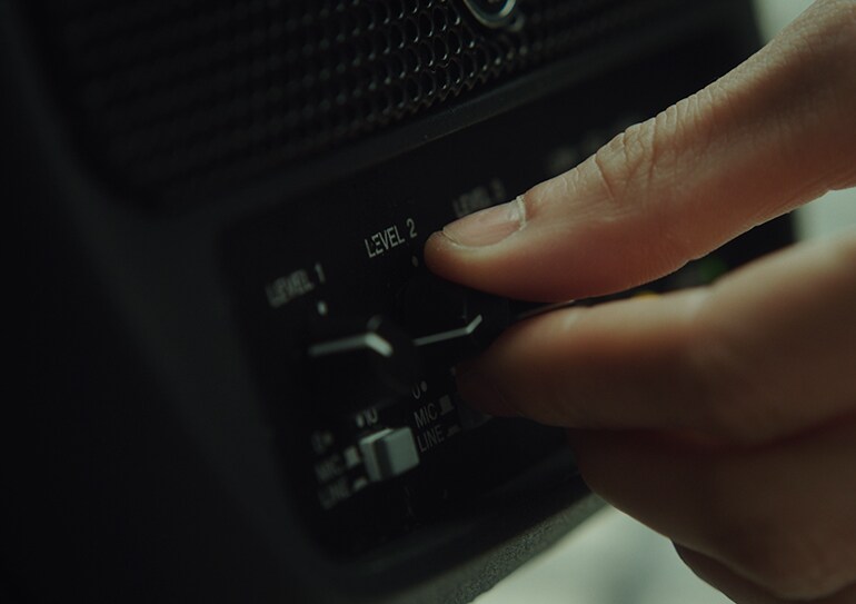 Closeup image of person adjusting knobs on the Stagepas 100.